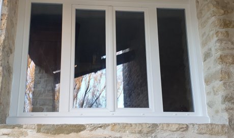 Ensemble  PVC en rénovation composé d'une fenêtre deux vantaux au centre et deux de fixes latéraux